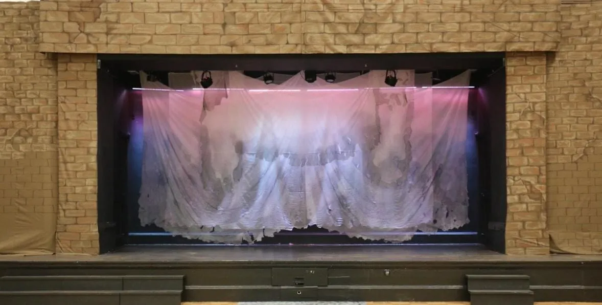 A stage with a curtain and lights Description automatically generated