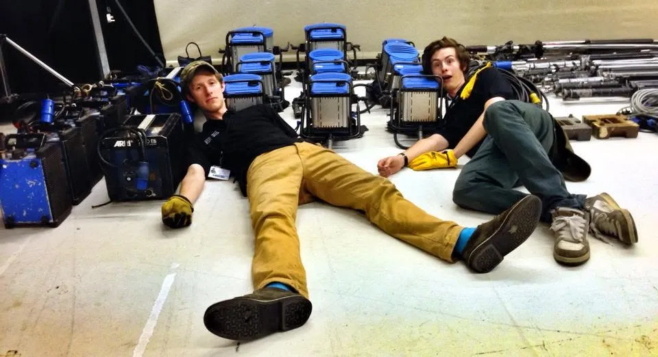 Elliot and Zander Weaver resting on the floor among film production equipment in 2012.