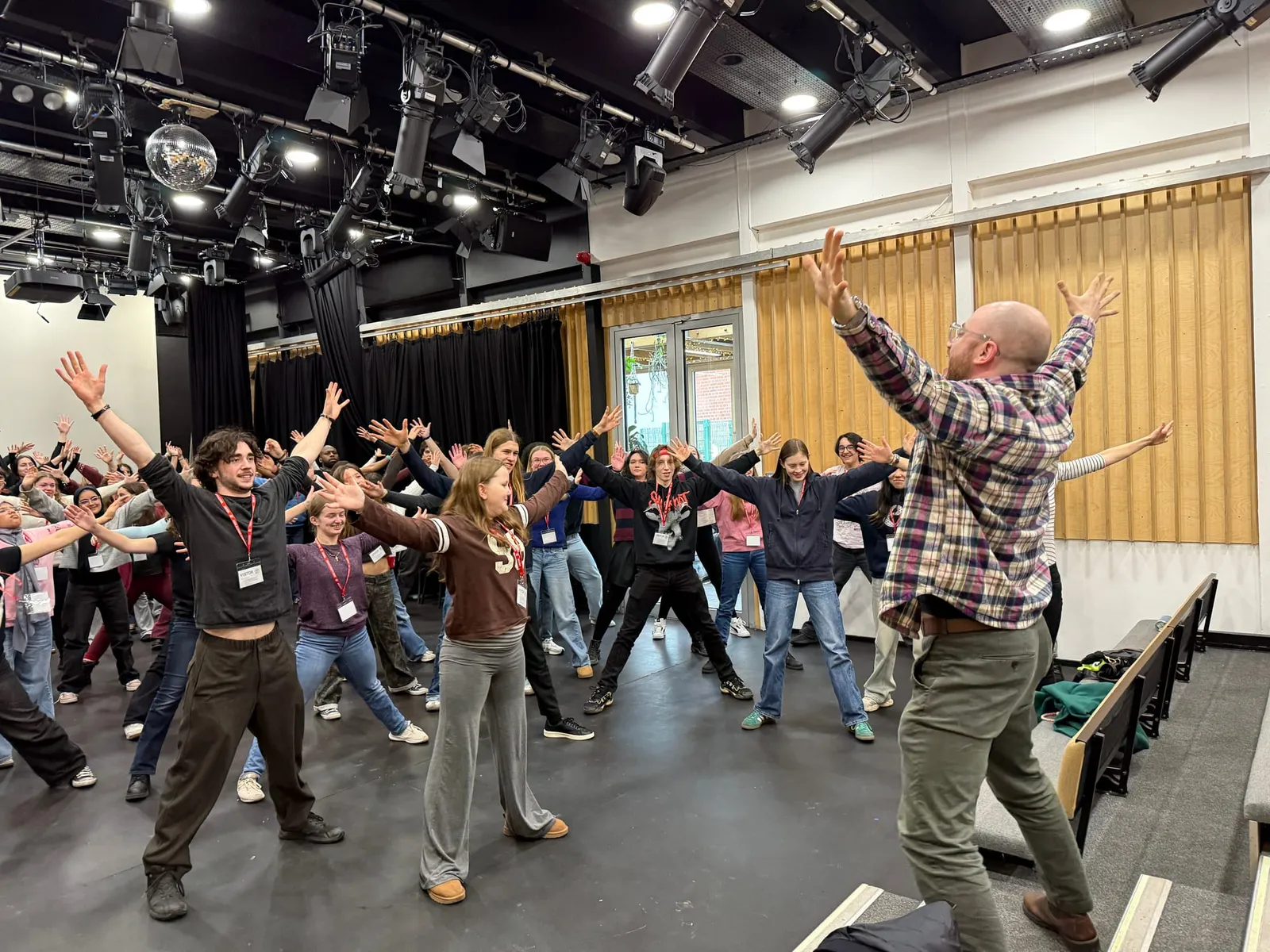 Ben leading a group of young artists in a physical warm-up at an ISTA festival.